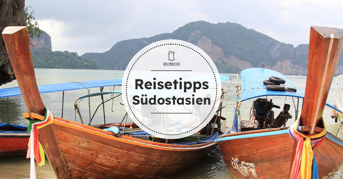 Typisches thailändisches Boot am Strand mit Bergen im Hintergrund